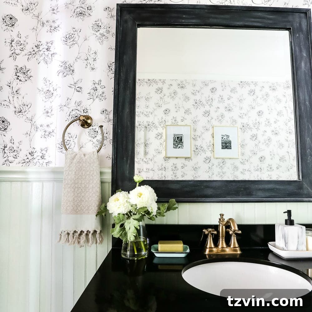 Two Years In: Our Home's Stunning Before and After 27 Square view of the powder room showcasing the contrasting colors and thoughtful decor, including a round mirror and a wall-mounted faucet.
