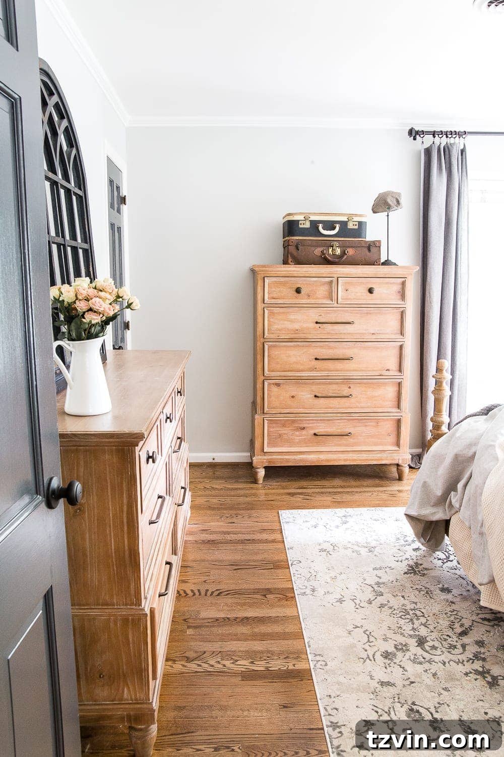 Two Years In: Our Home's Stunning Before and After 57 Detailed view of the master bedroom, showcasing decorative pillows, a bedside table with a lamp, and subtle wall art contributing to the calming ambiance.