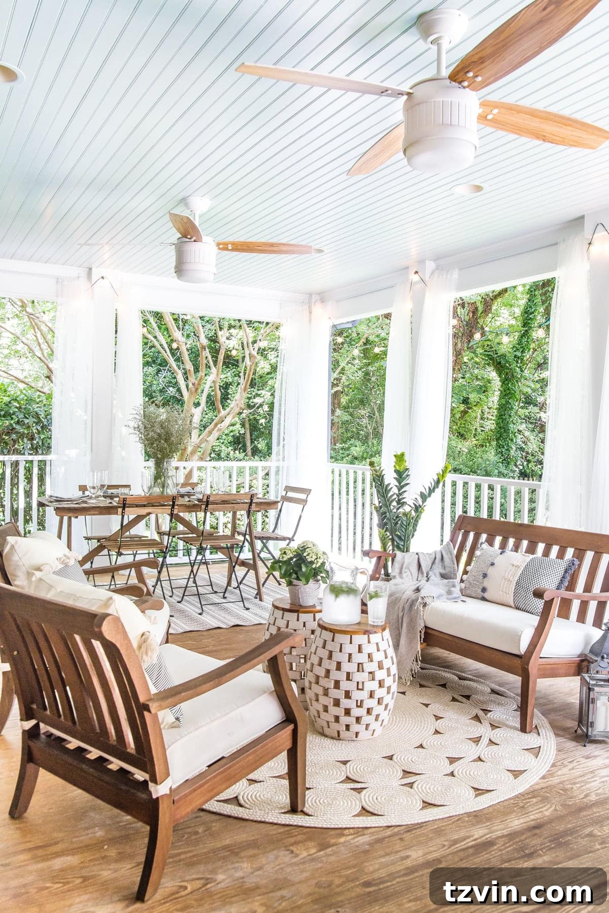 Two Years In: Our Home's Stunning Before and After 64 After image of a beautifully decorated back porch featuring a 'Haint Blue' ceiling, comfortable outdoor seating, and ambient string lights for summer entertaining.