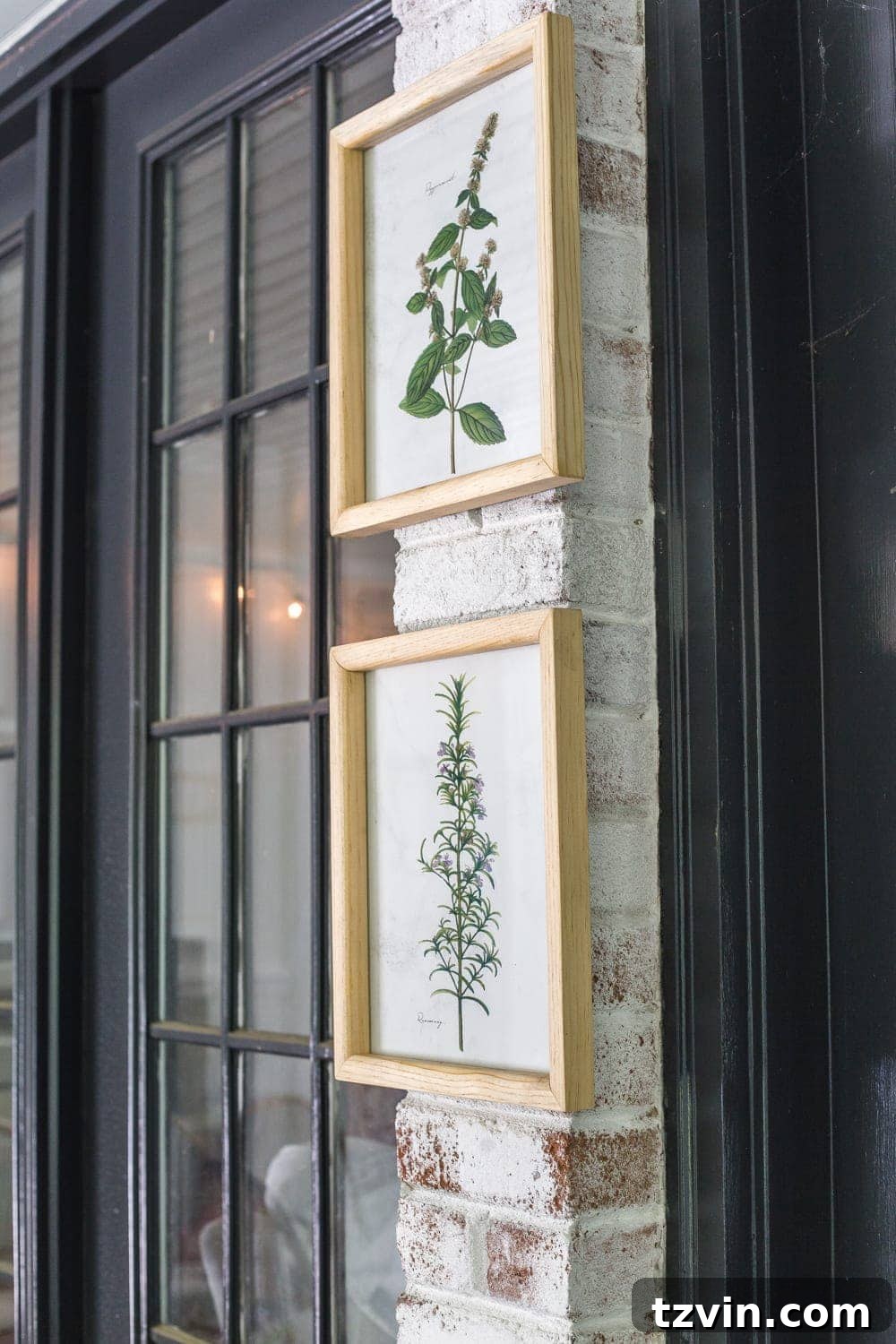 Botanical prints mounted on a limewashed brick wall on a tropical boho back porch, adding artistic flair.