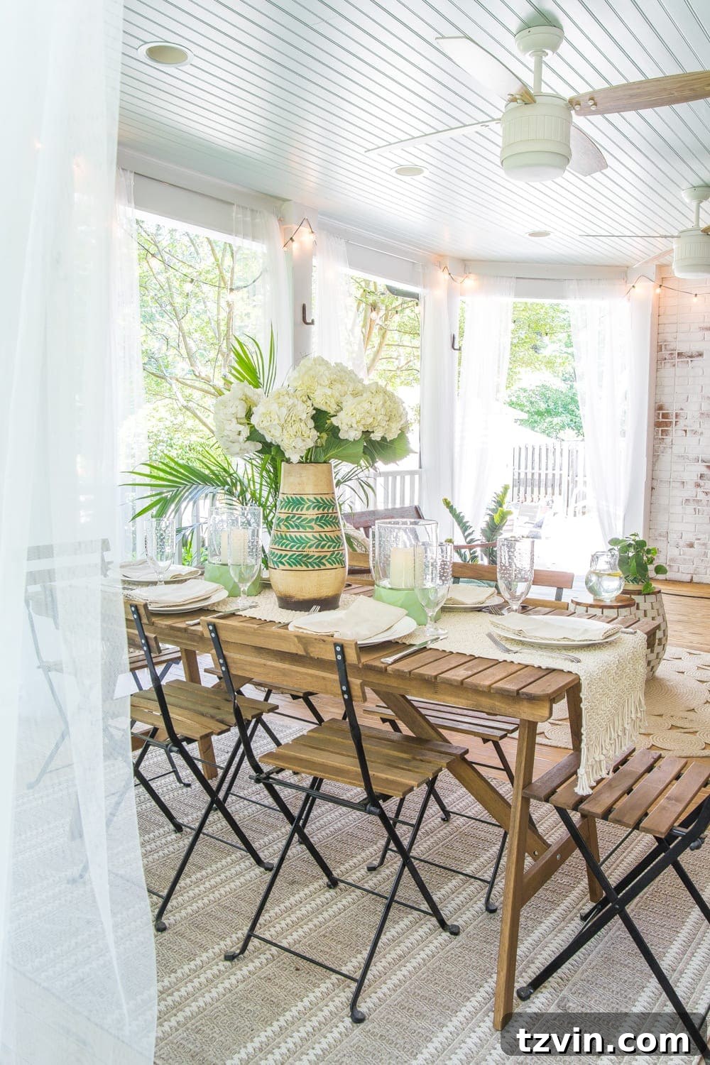 Outdoor dining table set for summer on a tropical boho back porch, ready for meals and morning coffee.