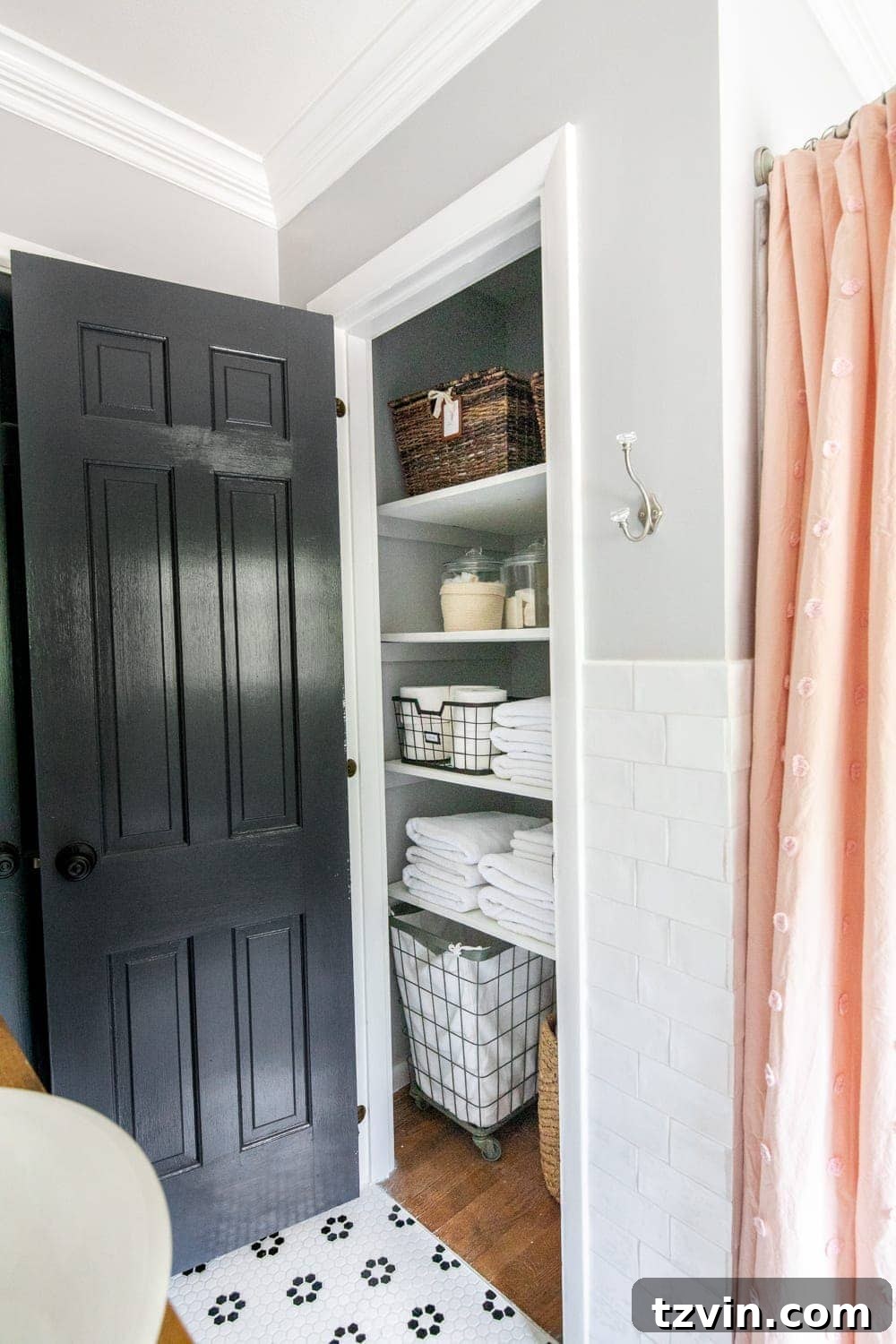 Tiny Humans Big Bathroom Makeover 18 Organized linen closet featuring baskets and neatly stacked towels