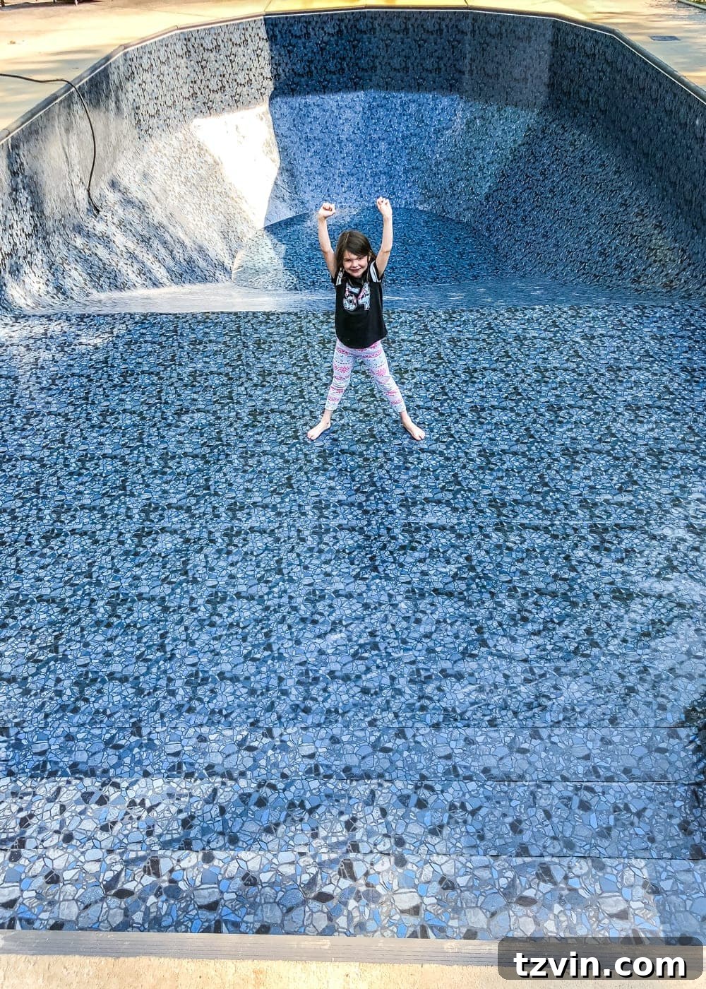 Young girl doing cartwheels in the shallow end of the newly installed Obsidian pool liner