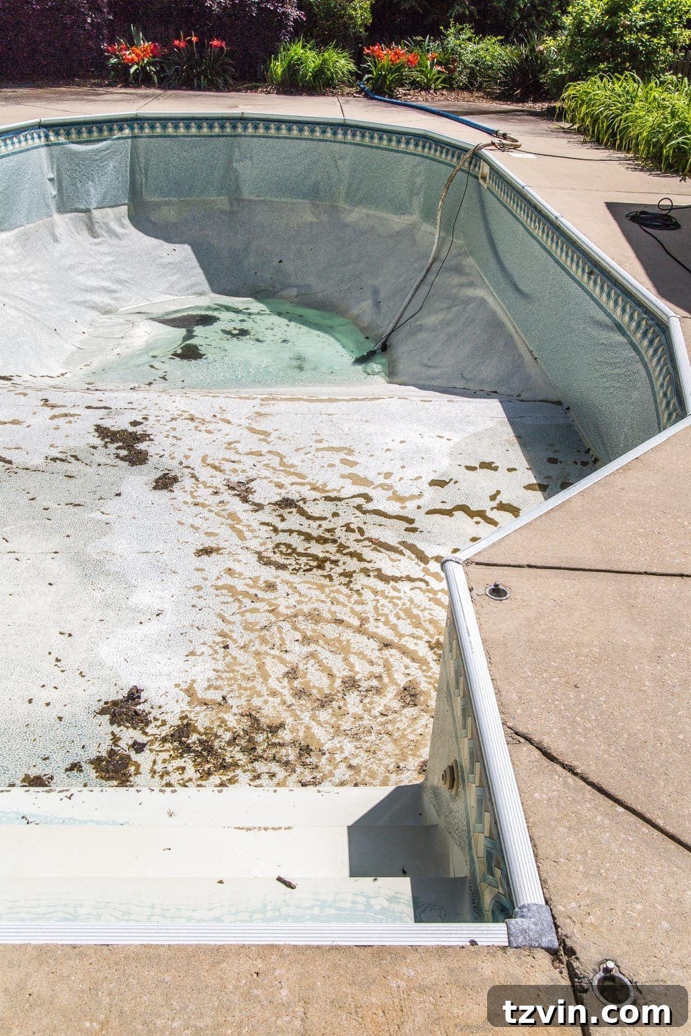 Pool completely drained, showing the old, worn-out liner before removal