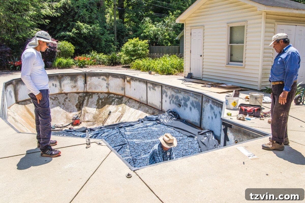 Pool liner being installed by professionals, carefully fitting the new vinyl