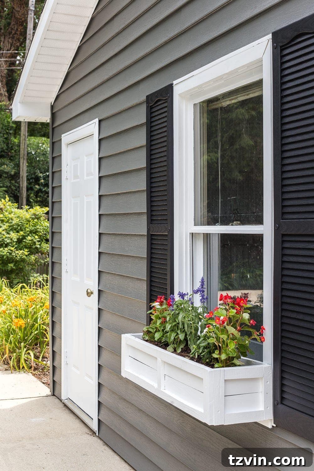 Close-up of DIY window box made from scrap wood on the newly painted pool shed
