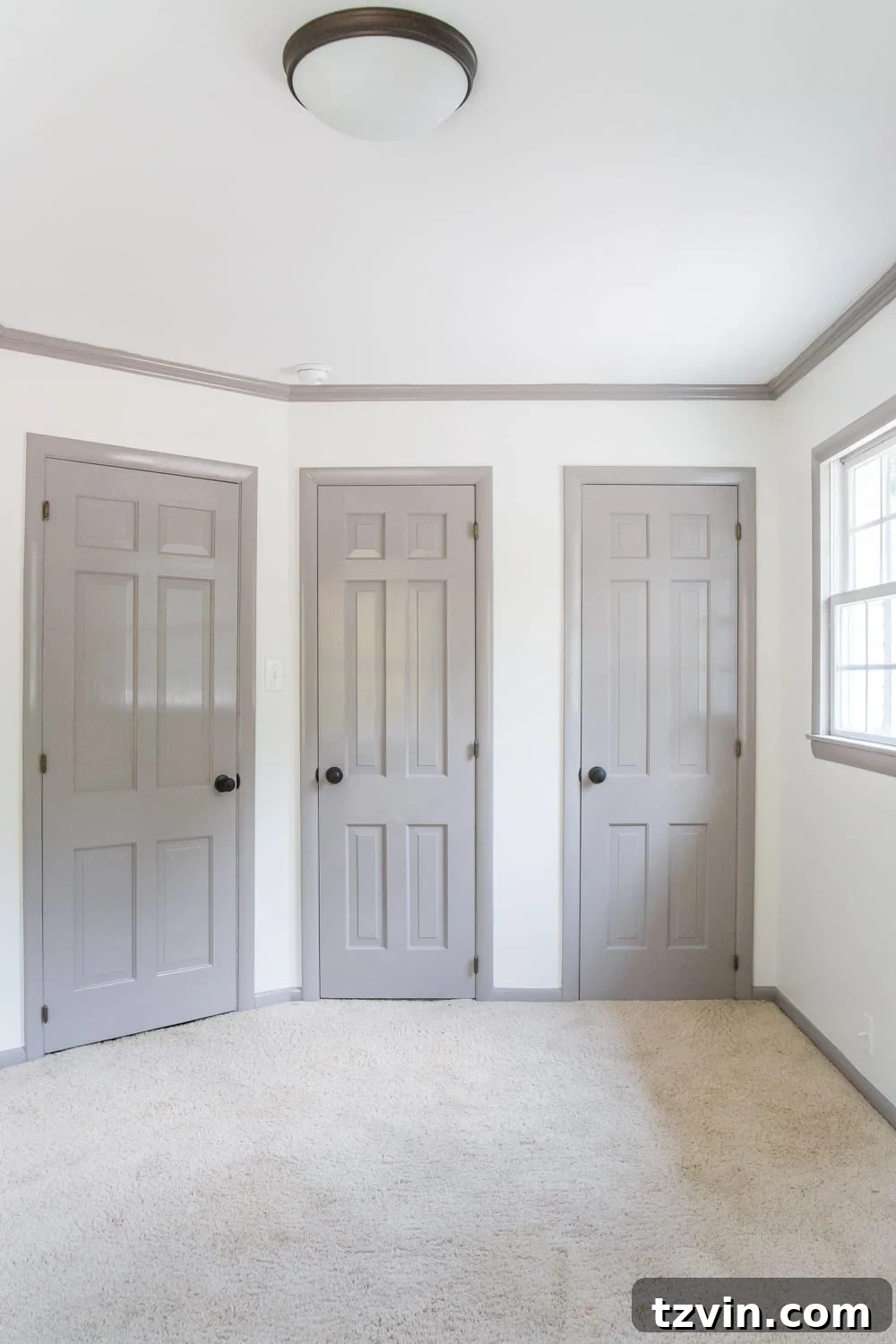 Newly painted guest bedroom with Benjamin Moore Swiss Coffee white walls and Winter Gates gray trim