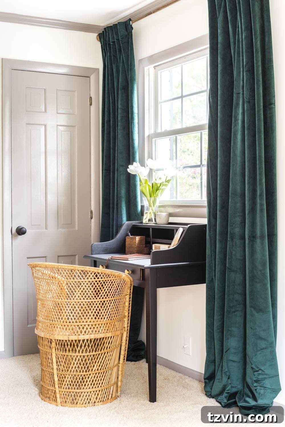 Green velvet curtains and vintage desk in guest bedroom