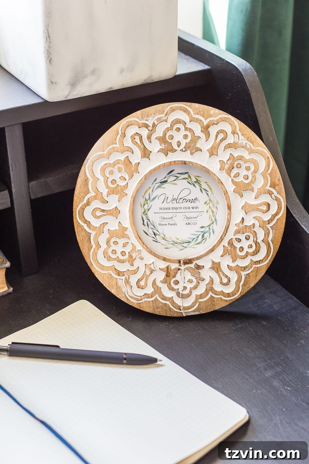 A beautifully framed Wi-Fi password sign on a bedside table, a thoughtful and essential amenity for modern guests.