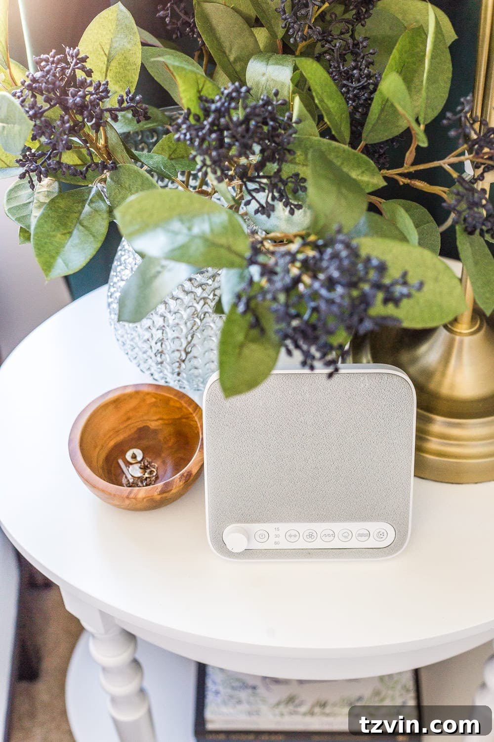 A bedside table with a sound machine and a small dish for jewelry, showcasing thoughtful guest bedroom amenities for peace and organization.