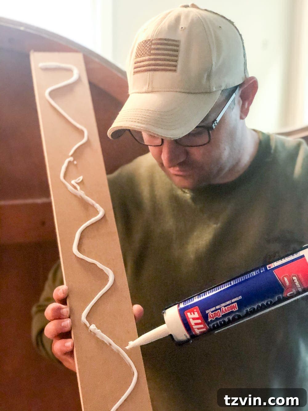 Applying construction adhesive to an MDF board for wall installation