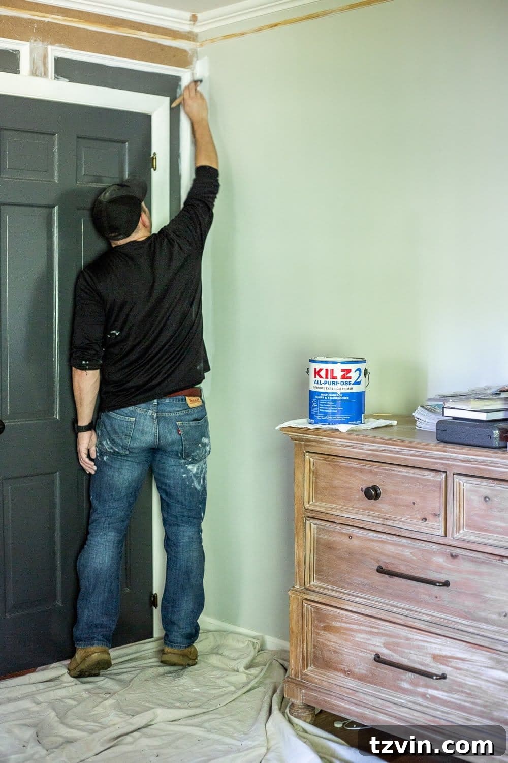 Master Bedroom Transformation: 5 Hard-Earned Painting Insights 8 A wall showing a sample of gray paint applied directly over sage green, demonstrating how previous colors can affect new paint without primer.