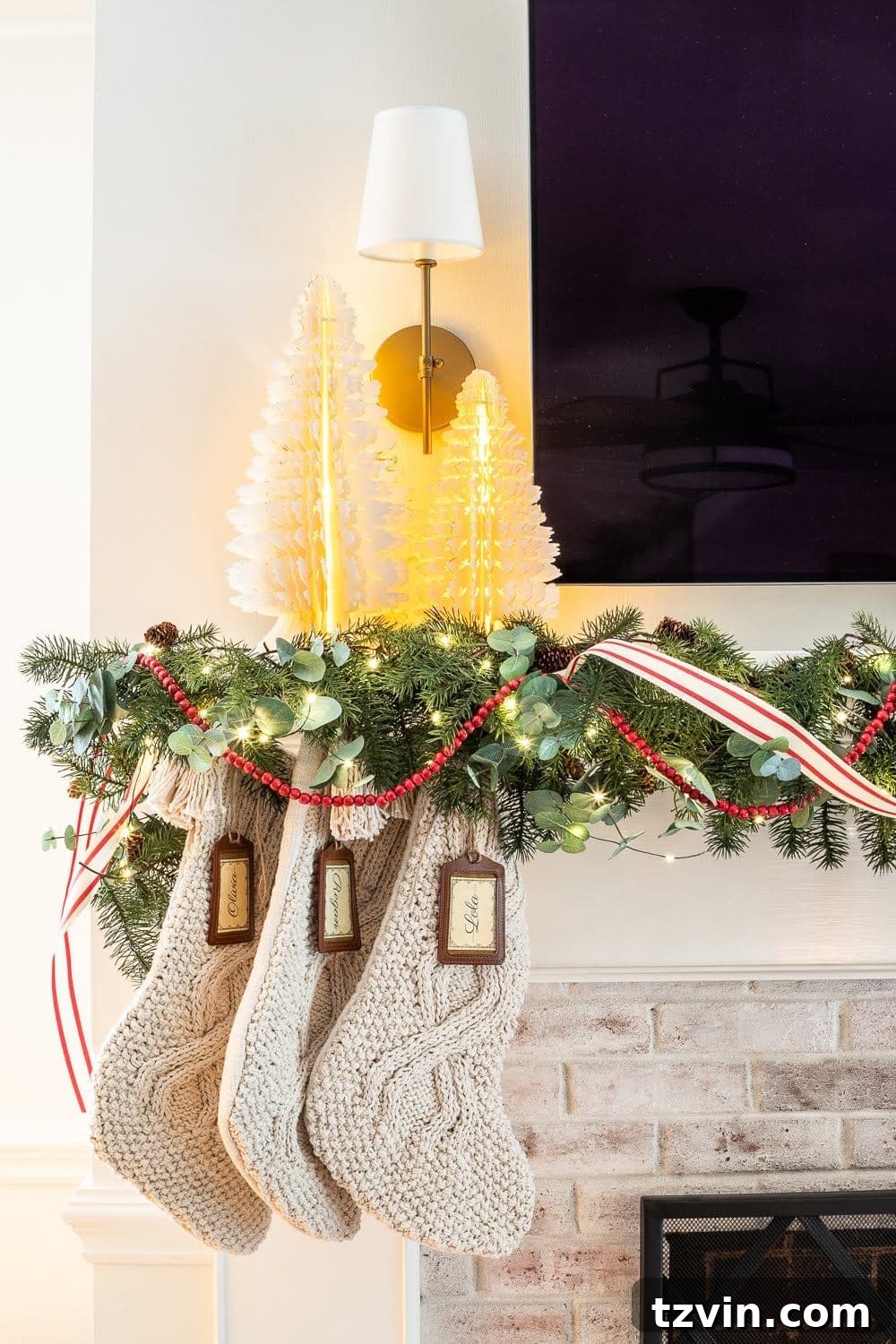 Swedish Christmas Charm: Blending Sentimental Decor with Modern Touches 20 Swedish Christmas decor featuring paper tree figurines, chunky knit stockings, abundant greenery, and fairy lights for a cozy, festive feel.