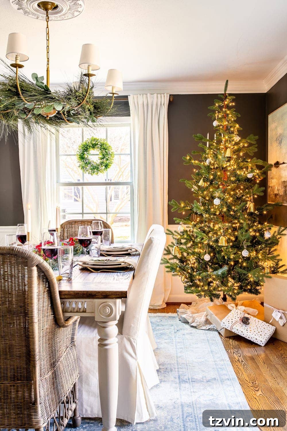 Christmas decorating ideas: Dining room with festive tree, chandelier garland, and window wreaths