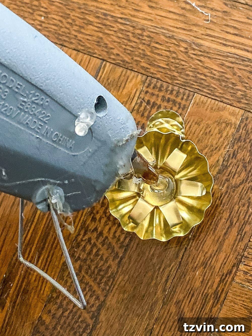 Heirloom Christmas Tree Candles: Handcrafted Charm 6 applying hot glue to the inside of a brass candle holder clip
