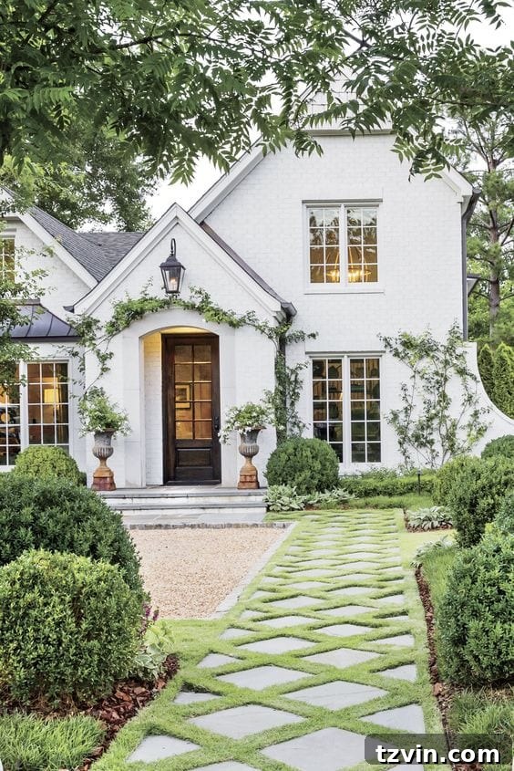 Inspirational image of a grand house exterior with manicured hedges and a paver walkway.
