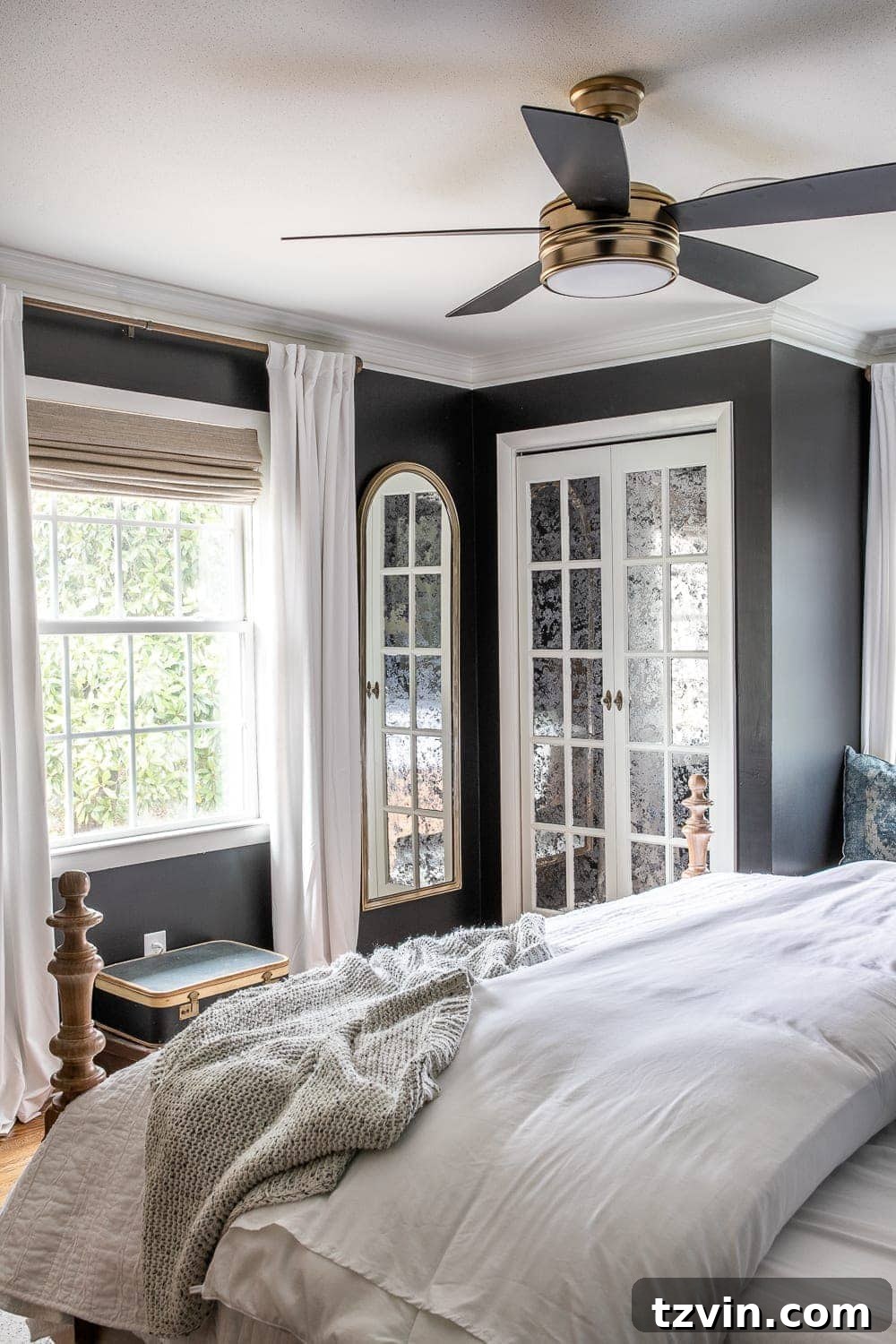 Moody Modern Vintage Master Bedroom Transformation 11 Master bedroom with elegant French bifold closet doors painted white with antique mirror film, contrasting against black walls.