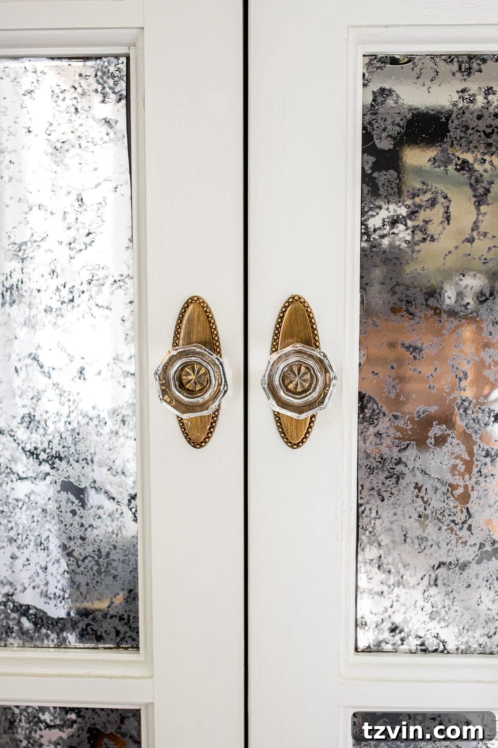 Moody Modern Vintage Master Bedroom Transformation 12 Close-up of antique style gold and glass knobs on French bifold closet doors, providing a luxurious detail.