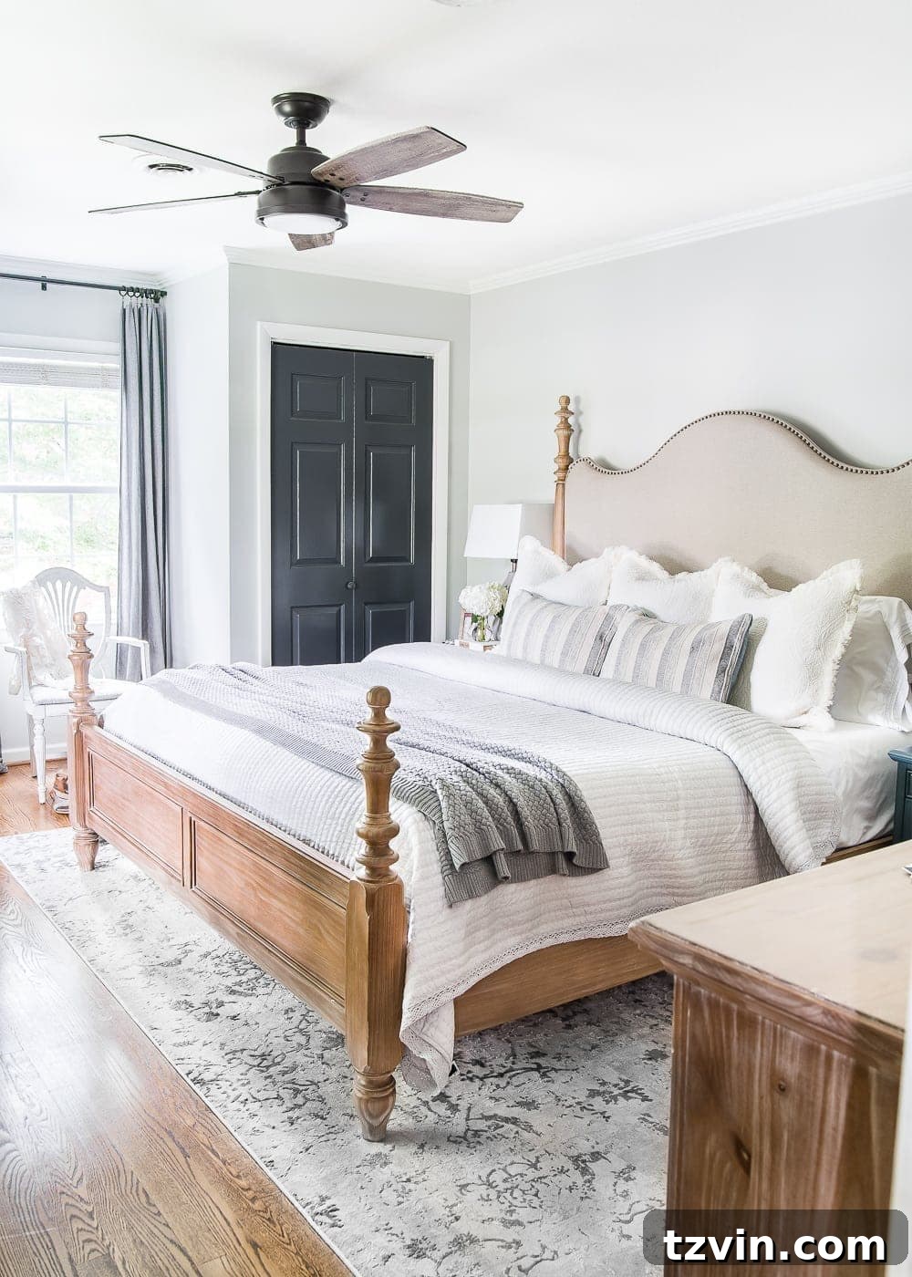 Moody Modern Vintage Master Bedroom Transformation 3 French farmhouse style master bedroom with light gray walls and warm wood furniture.