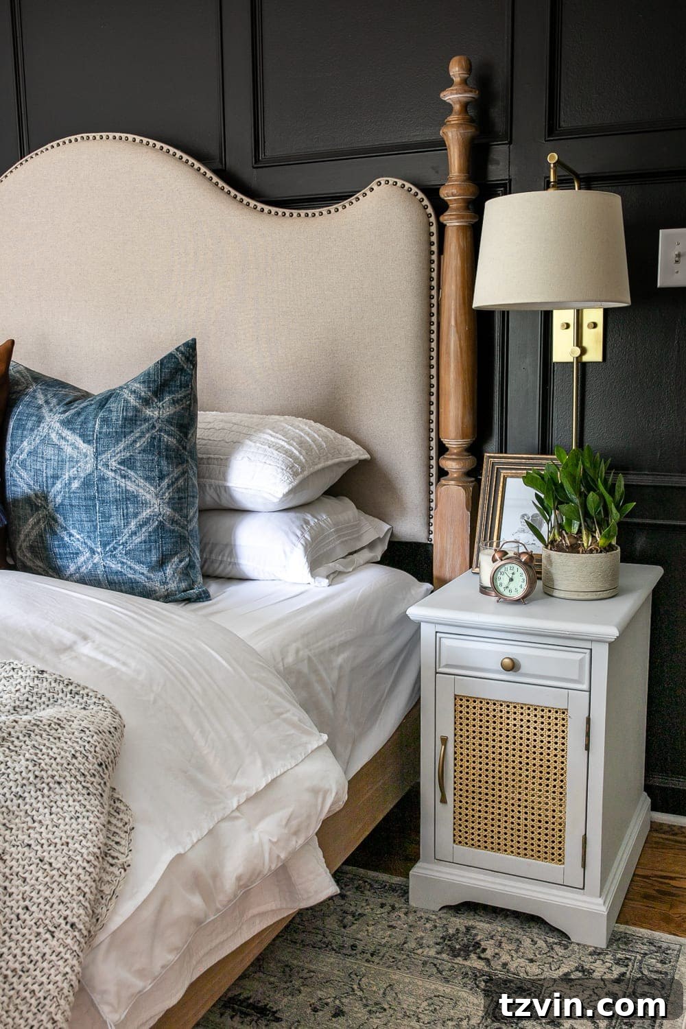 Moody Modern Vintage Master Bedroom Transformation 8 Refreshed nightstand in a moody modern vintage master bedroom, featuring cane webbing and white paint against a black wall.