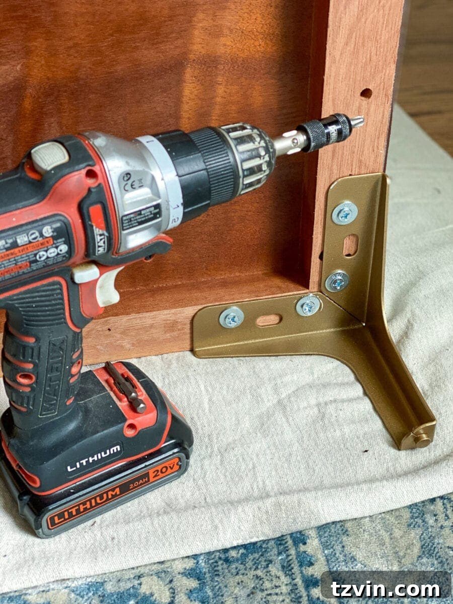 Chic Transformation of a Footed Grasscloth Buffet 5 Step 6: Spray painting new furniture legs with modern brass spray paint for a sophisticated finish