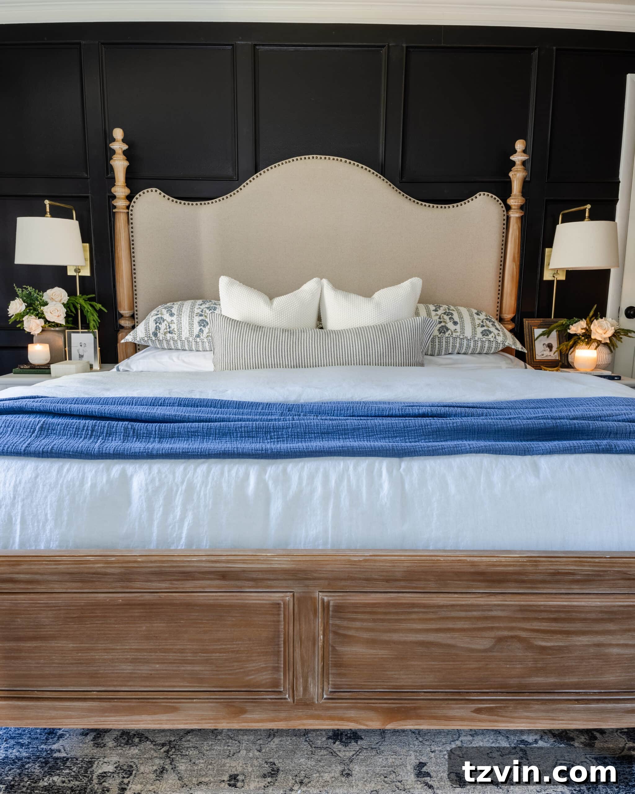 Black bedroom painted KILZ Rebel, featuring an upholstered wood poster bed and blue bedding, designed to evoke a dramatic and sophisticated feel.
