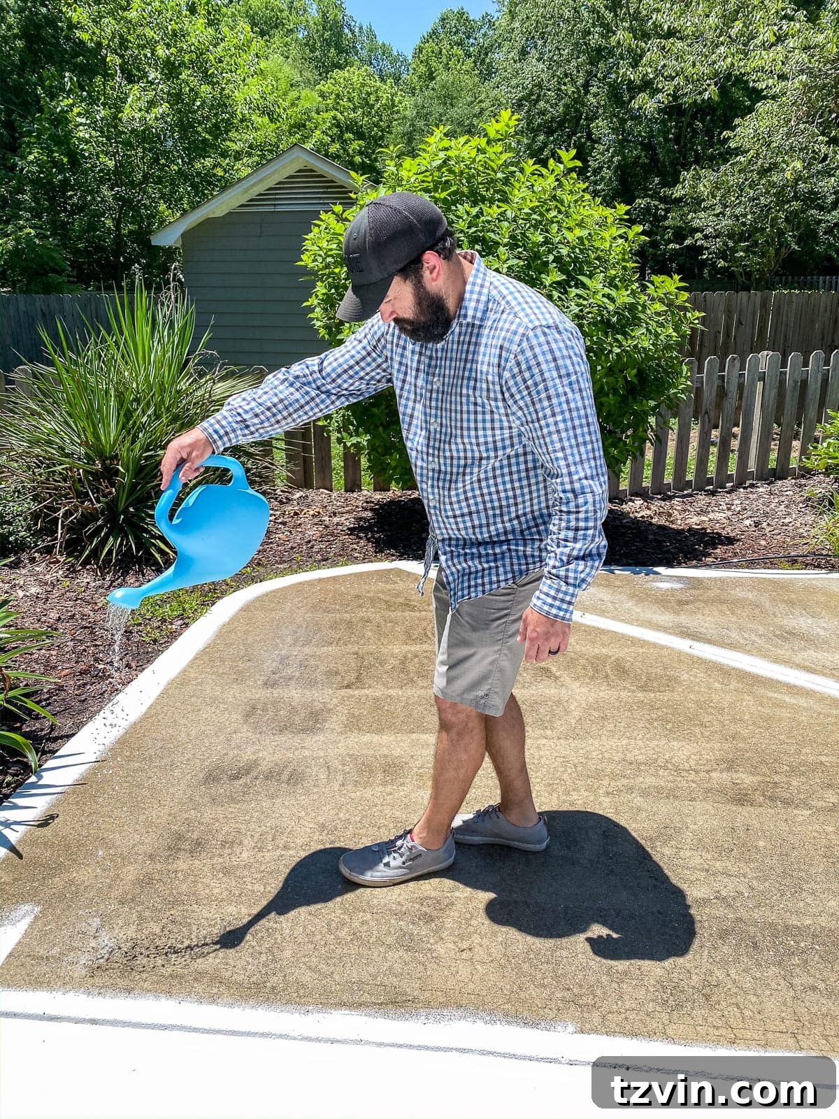 applying concrete etcher and cleaner with a watering can