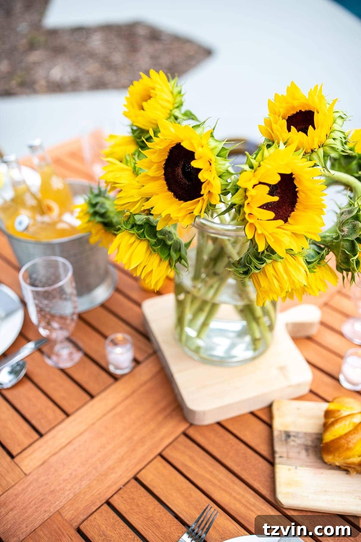 Summer Patio Refresh and Al Fresco Dining Oasis 7 Close-up of outdoor dining table decor, featuring a wood cutting board, blue napkins, and white plates.