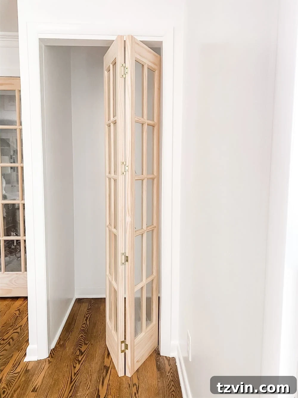 Simple Closet Transformation: Shelves and French Doors 3 Newly installed French closet doors in a home office, painted a dark accent color, with a hint of built-in shelving visible inside.