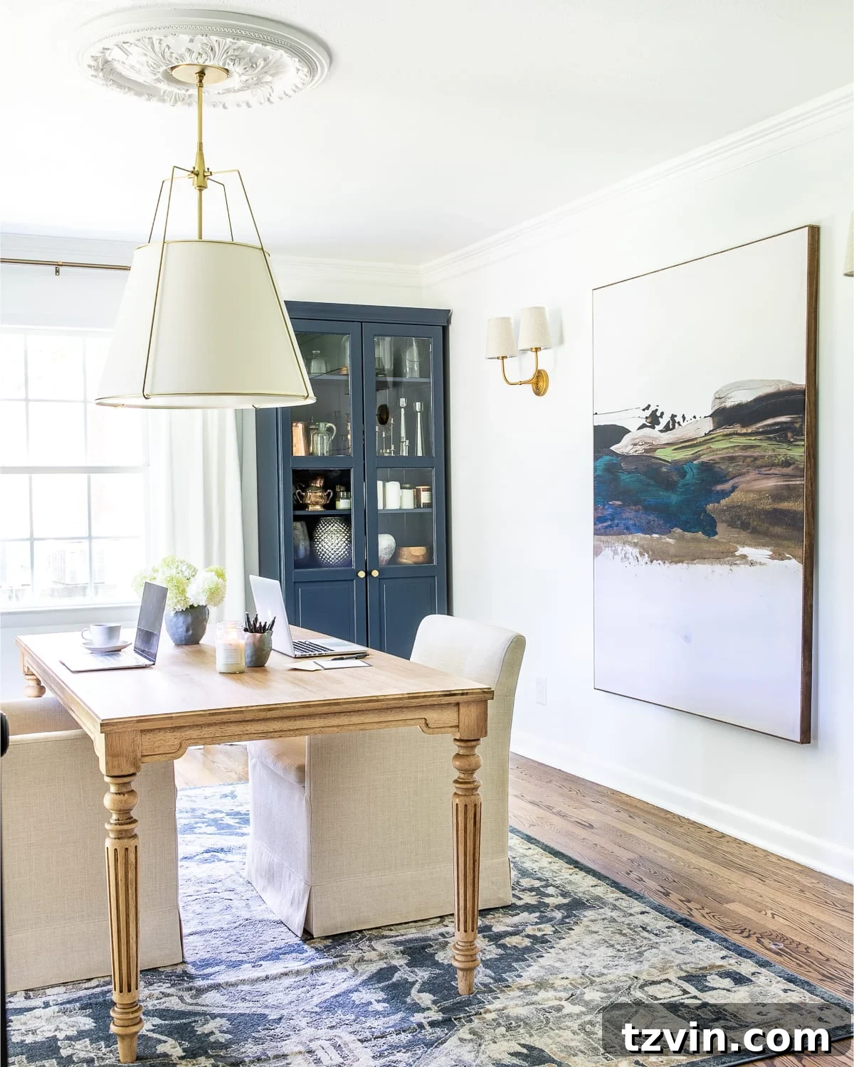 Our Home Office Transformation Unveiled 11 Home office featuring a large DIY shower curtain art piece, a central work table, and rolling upholstered chairs, creating an inspiring and budget-friendly decor.