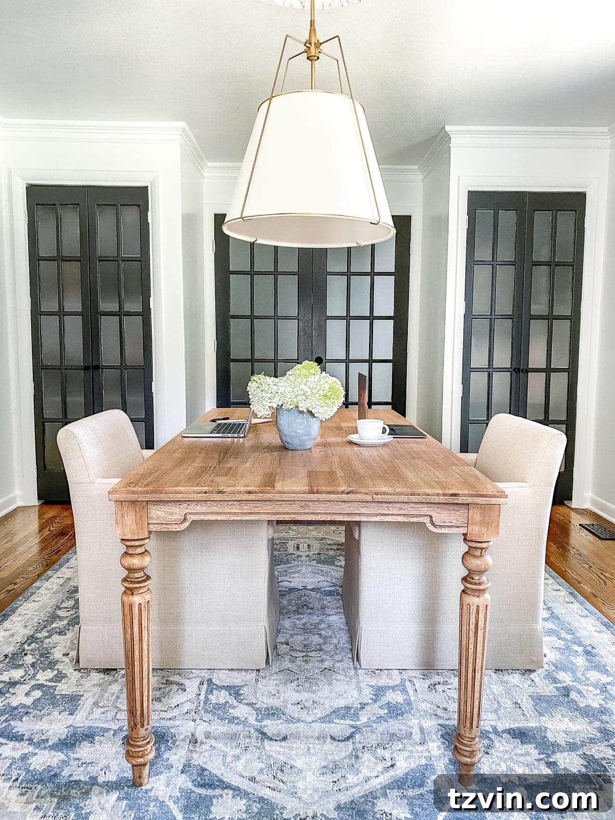 Our Home Office Transformation Unveiled 6 After image of the light and bright home office with a central desk, comfortable chairs, and functional storage, showcasing a complete transformation.