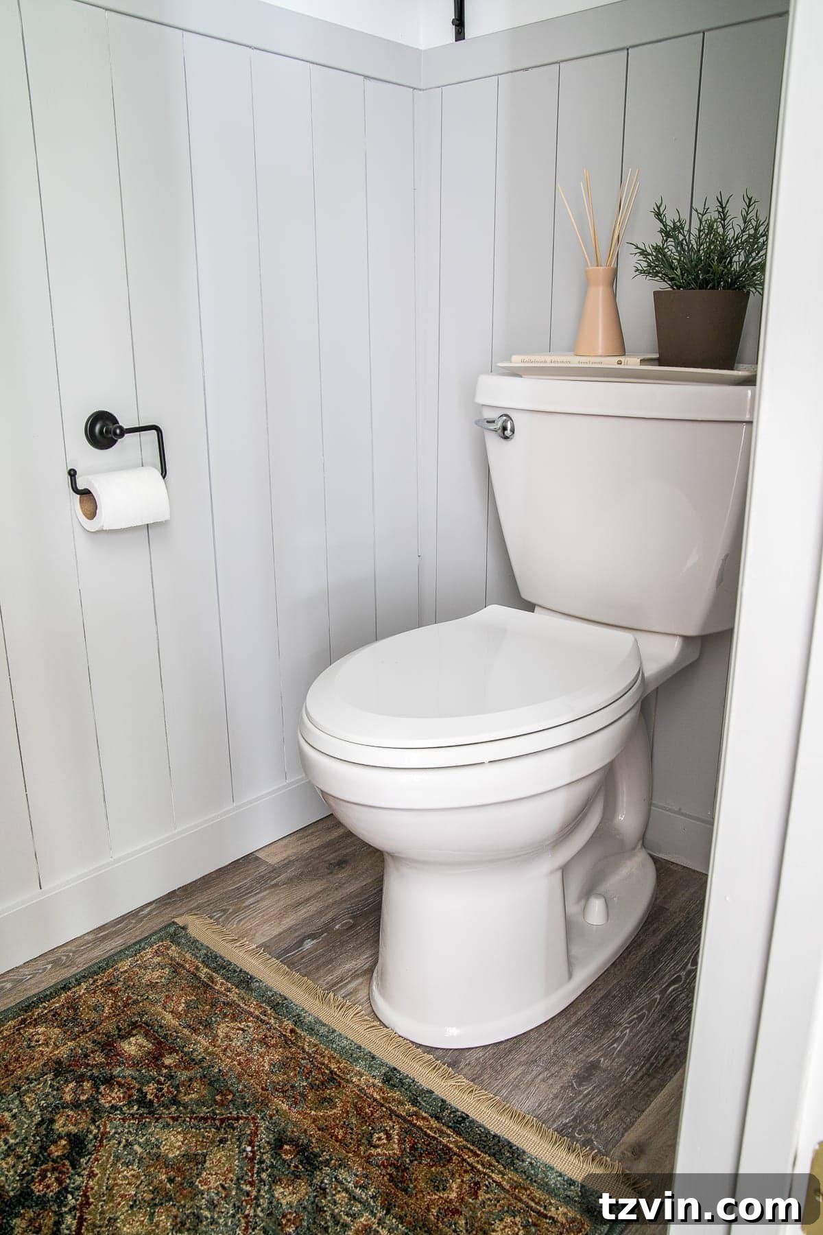 Small bathroom with vertical shiplap, a vintage style rug, and refreshed decor