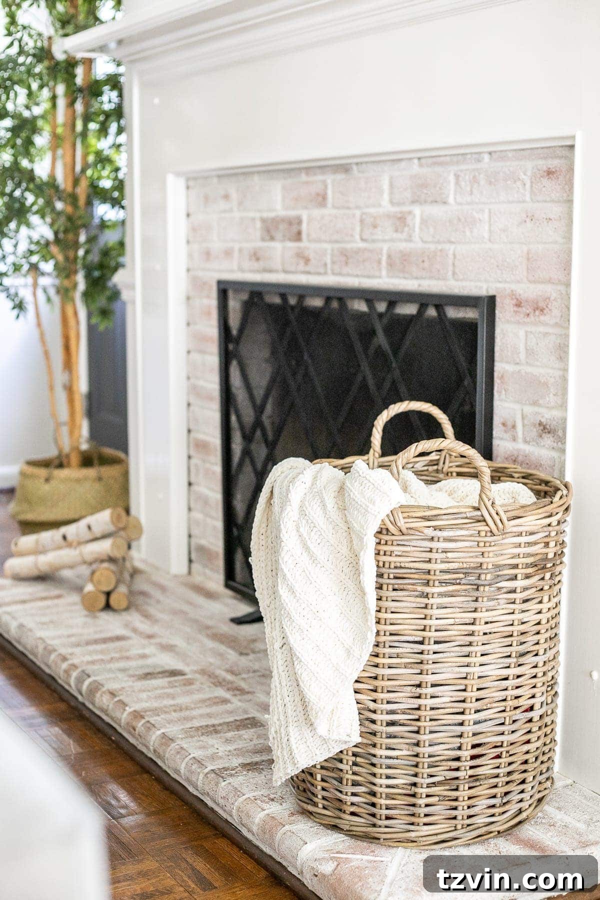 woven basket with cable knit throw blanket on limewashed brick fireplace