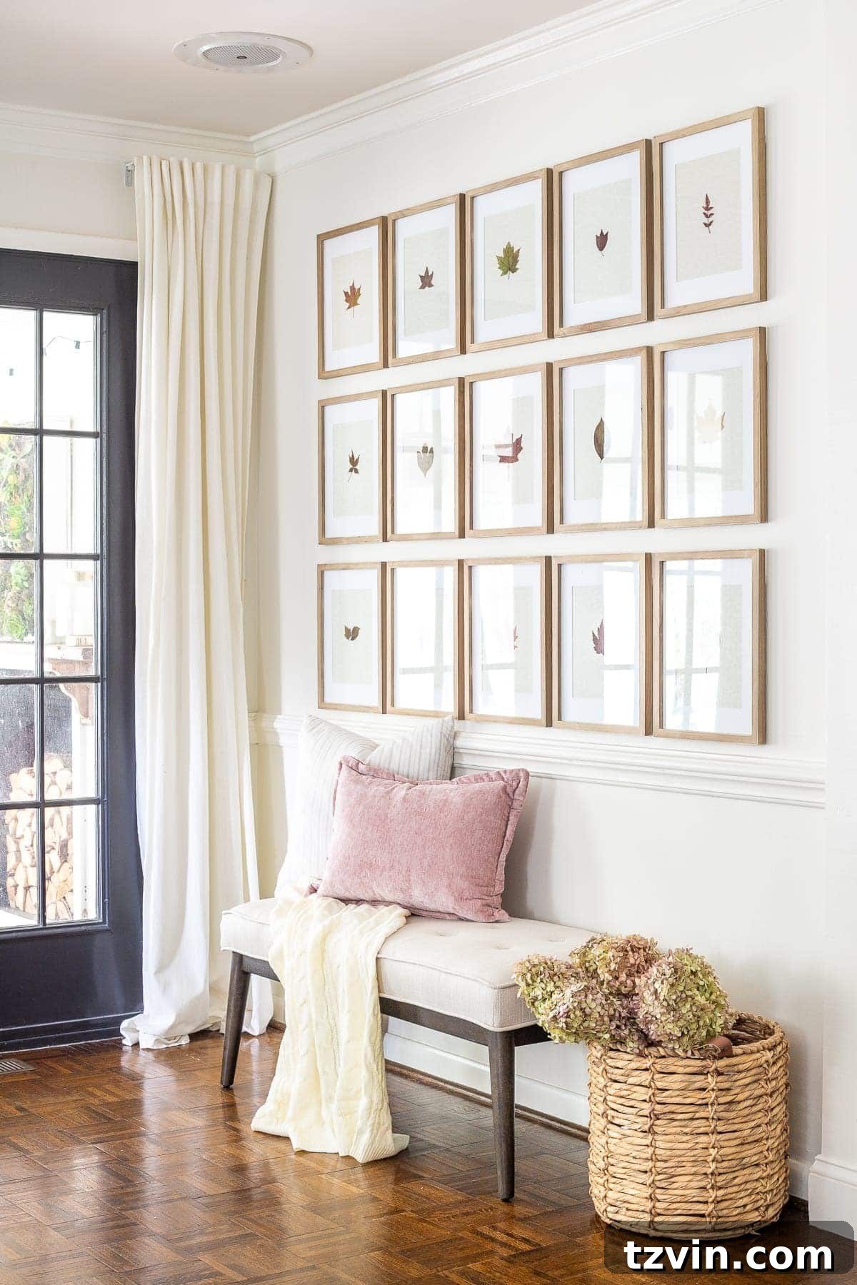 entryway decorated for fall with pressed leaf gallery wall and basket of dried hydrangeas