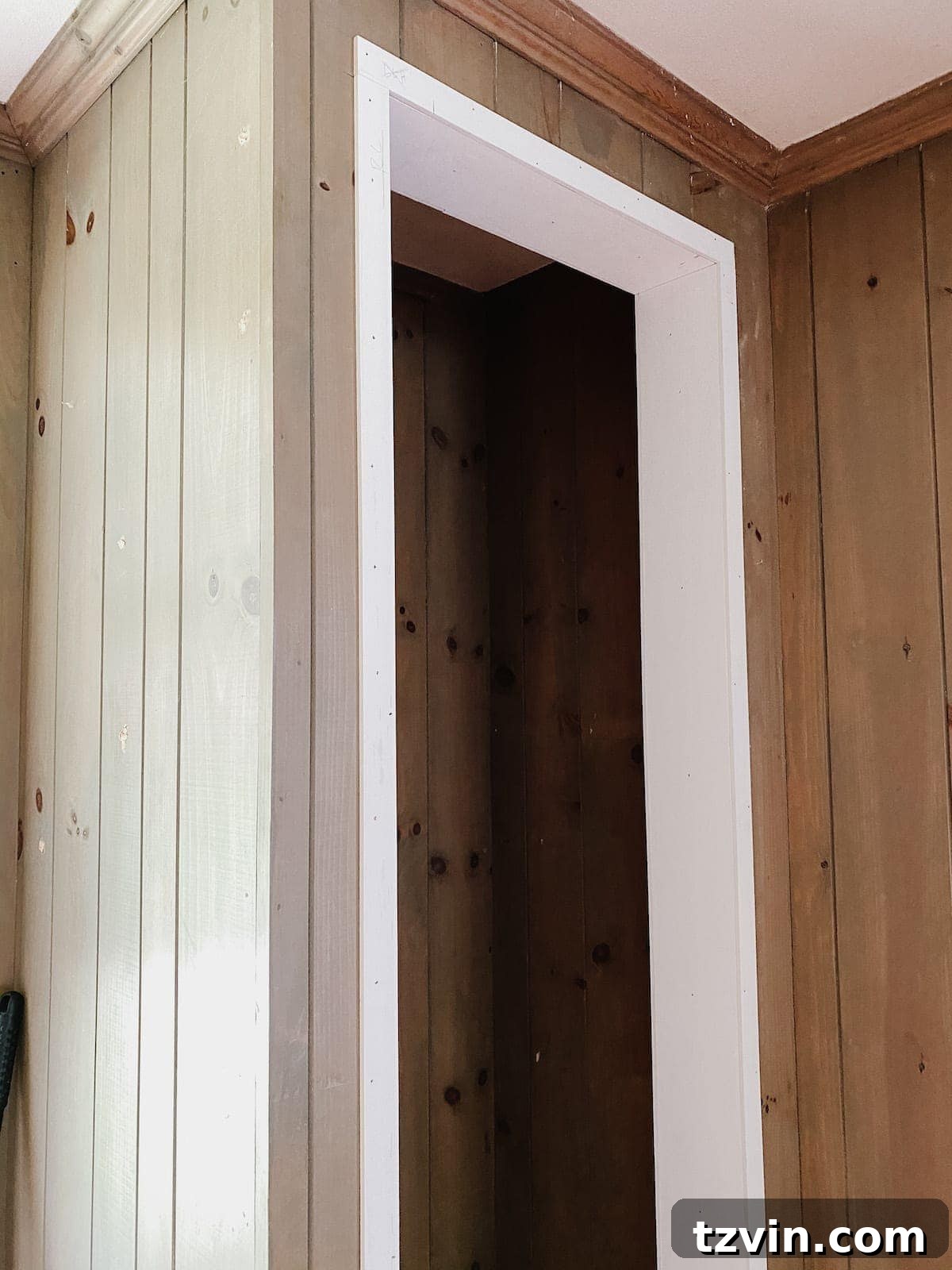 Applying caulk to the newly framed closet doorway