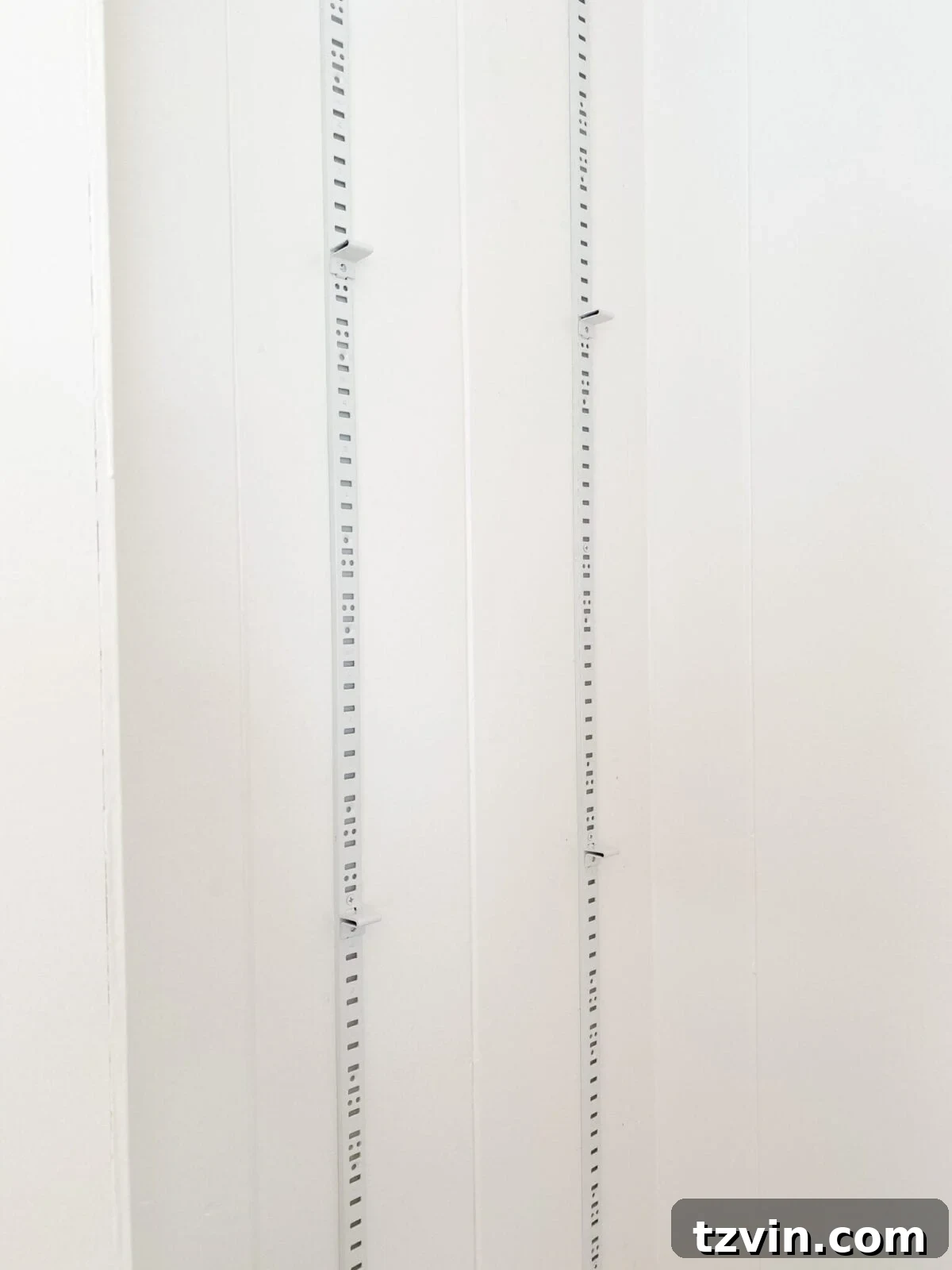 Close-up of adjustable built-in shelf brackets installed with pilaster strips