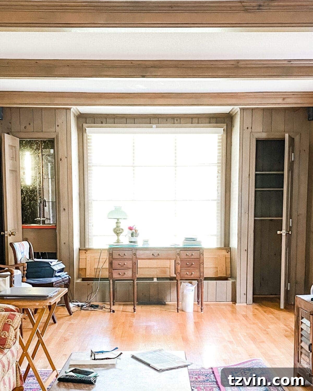 Before image of the living room office with dark paneling and old closets