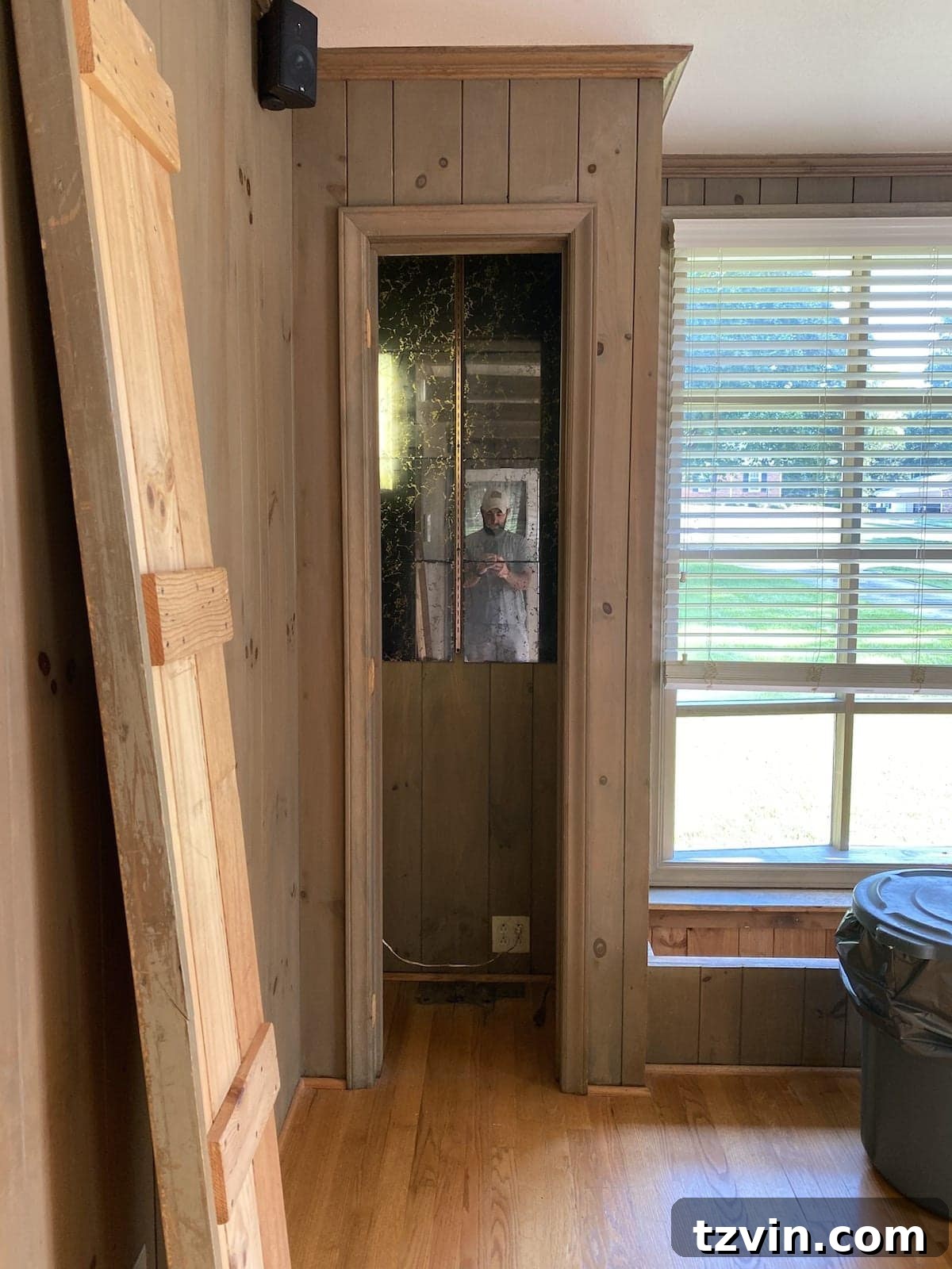Two old, dark wood-paneled closets before conversion to built-in shelves
