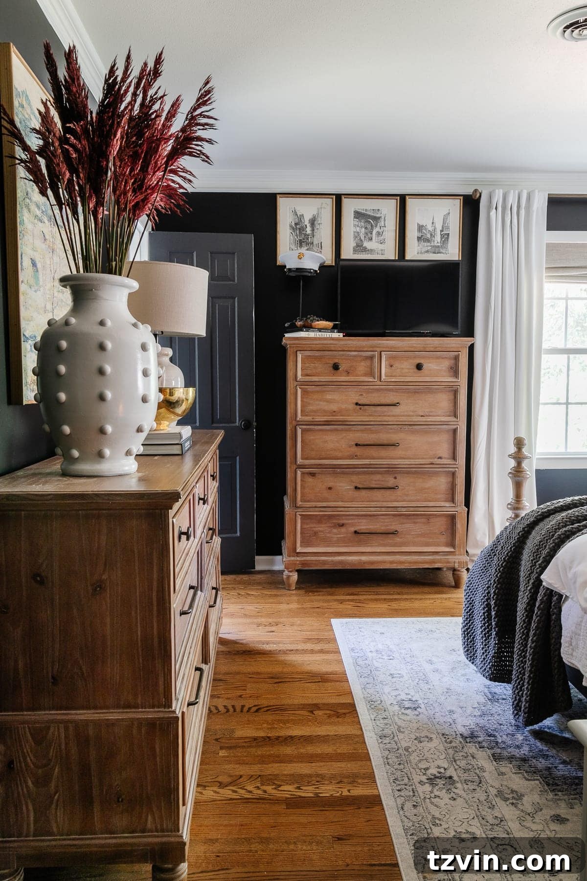 Elegant black bedroom with wood furniture decorated with subtle fall accents, creating a cozy and inviting atmosphere.