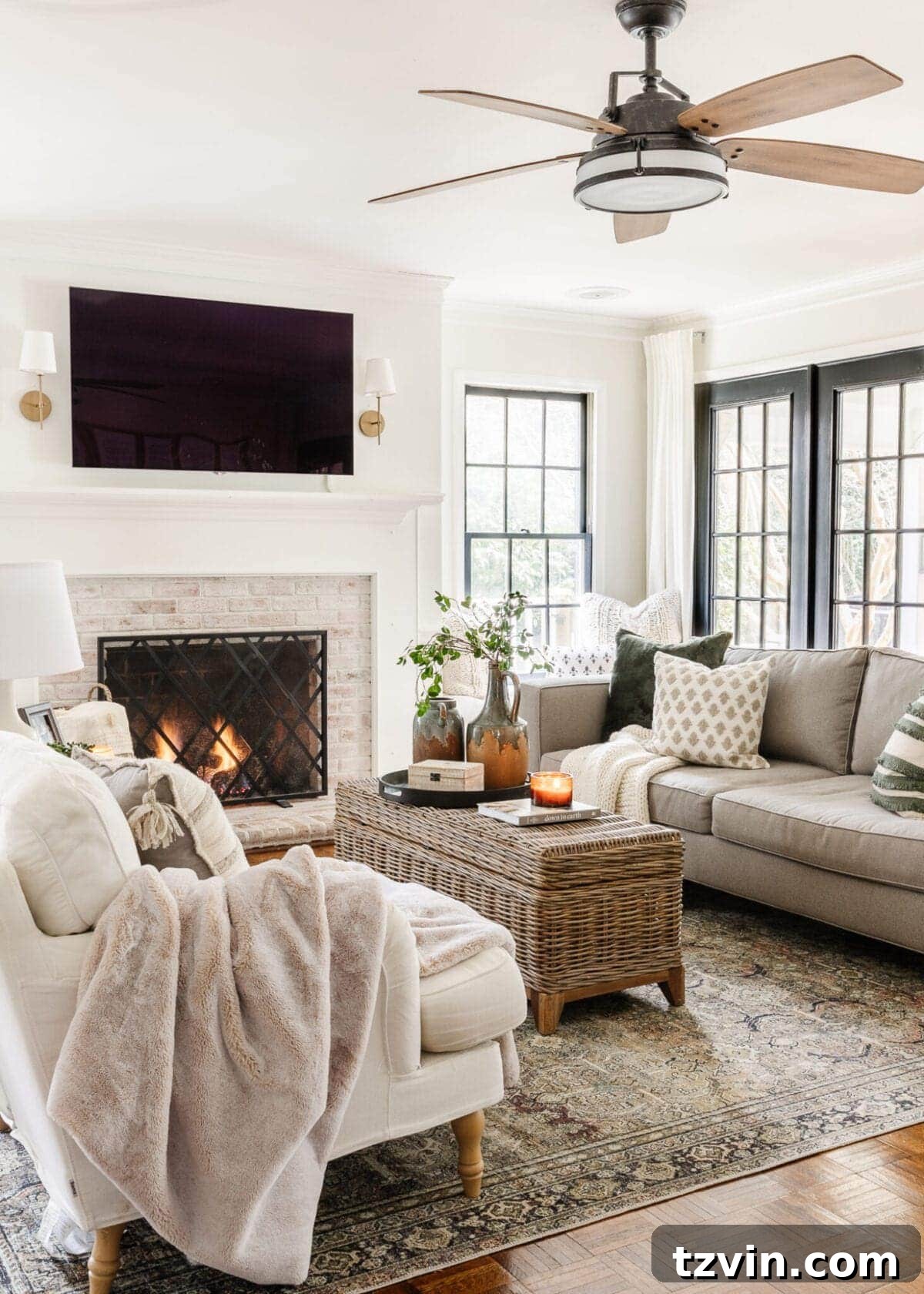 My Favorite Winter Living Room Touches 3 An inviting living room showcasing winter decor with a mix of fresh greens, warm blankets, and natural textures, enhancing a neutral color scheme.
