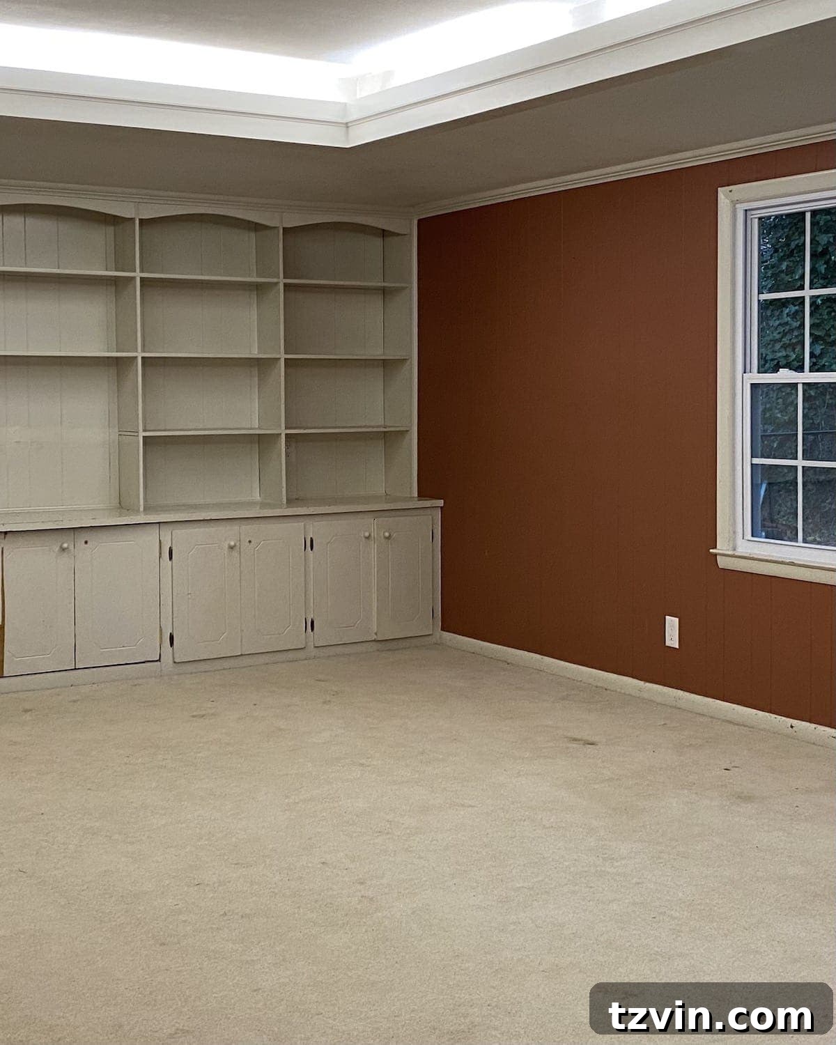 Before image of a cluttered and dark rec room awaiting a makeover.