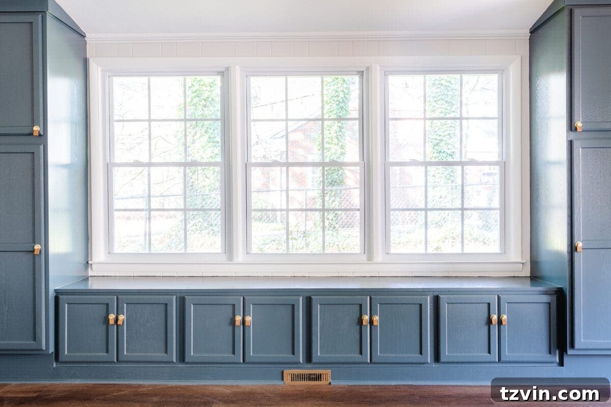 Close-up of a stylish rec room wall painted in Romabio Feather, featuring a decorative mirror and plant.