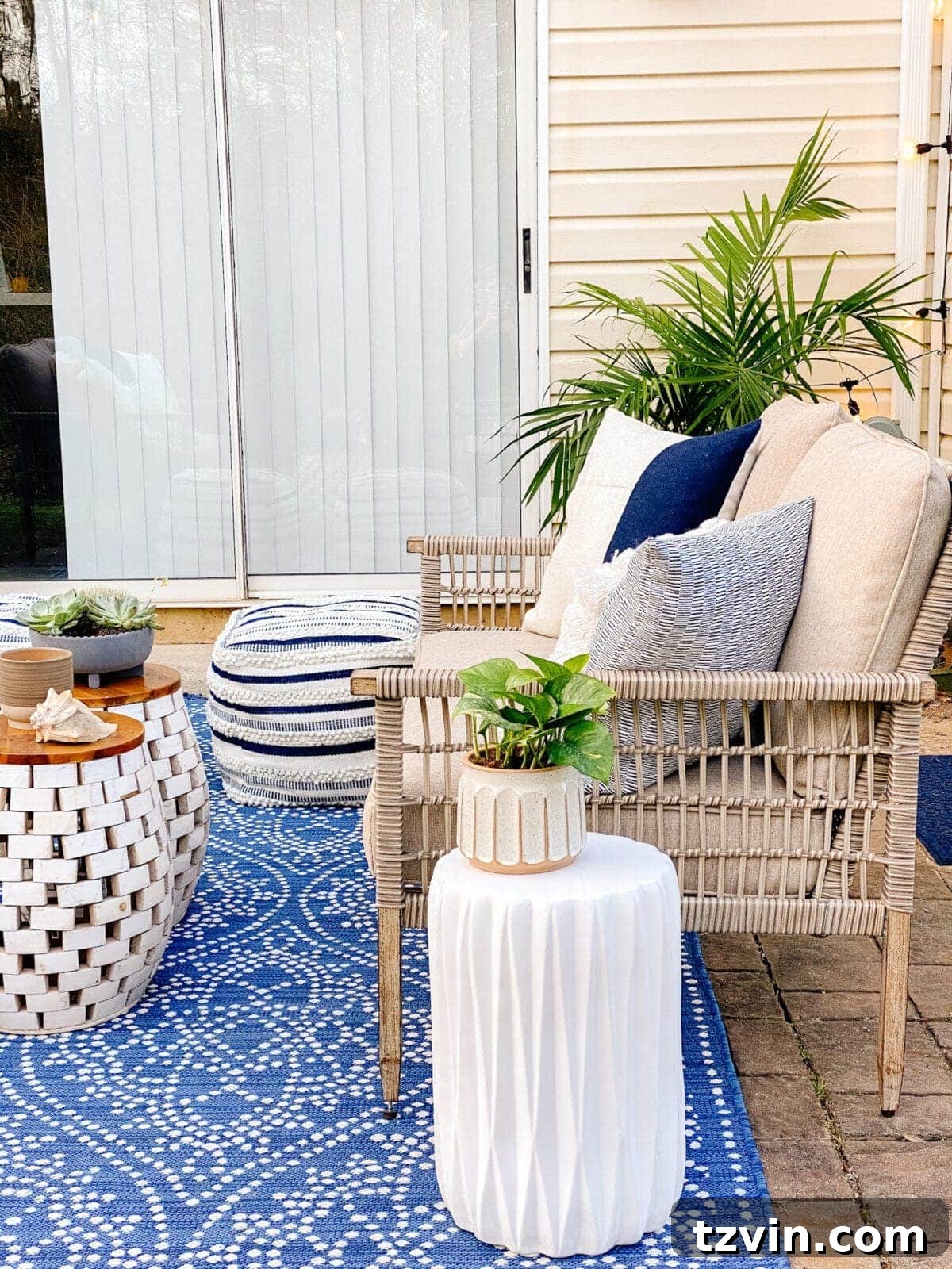 outdoor loveseat with pillows and palm tree on a patio