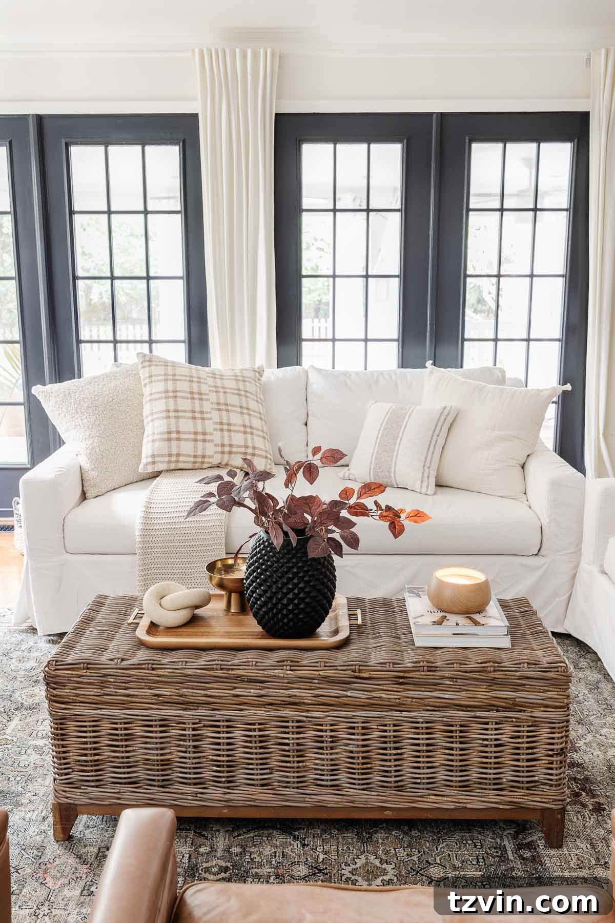 Here's the original title, followed by a single, unique, and engaging alternative: Original: Easy Coffee Table Decor Ideas and How to Style Them Alternative: Coffee Table Chic: Simple Styling Secrets 3 coffee table decor ideas with rattan coffee table trunk, black vase with fall stems, wooden candle, coffee table books, wooden tray, brass bowl, and stone knot sculpture