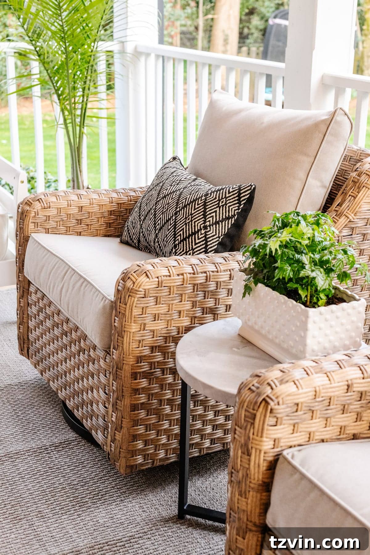 Back Porch Bliss Makeover 4 Two cozy outdoor swivel chairs with a small, practical side table between them, part of a stylish porch conversation set.