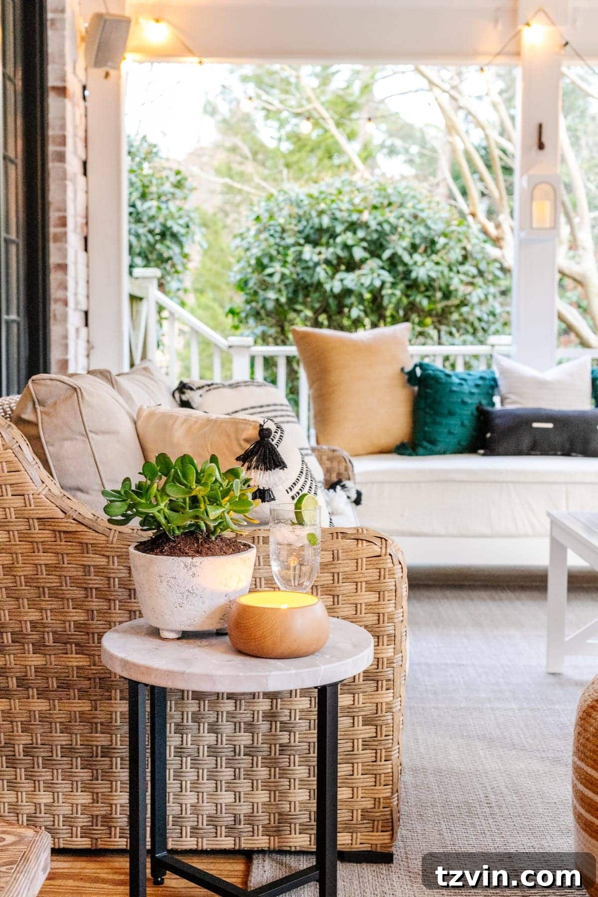 Back Porch Bliss Makeover 7 A chic faux marble end table positioned next to an outdoor daybed, holding a small potted plant and a refreshing drink.