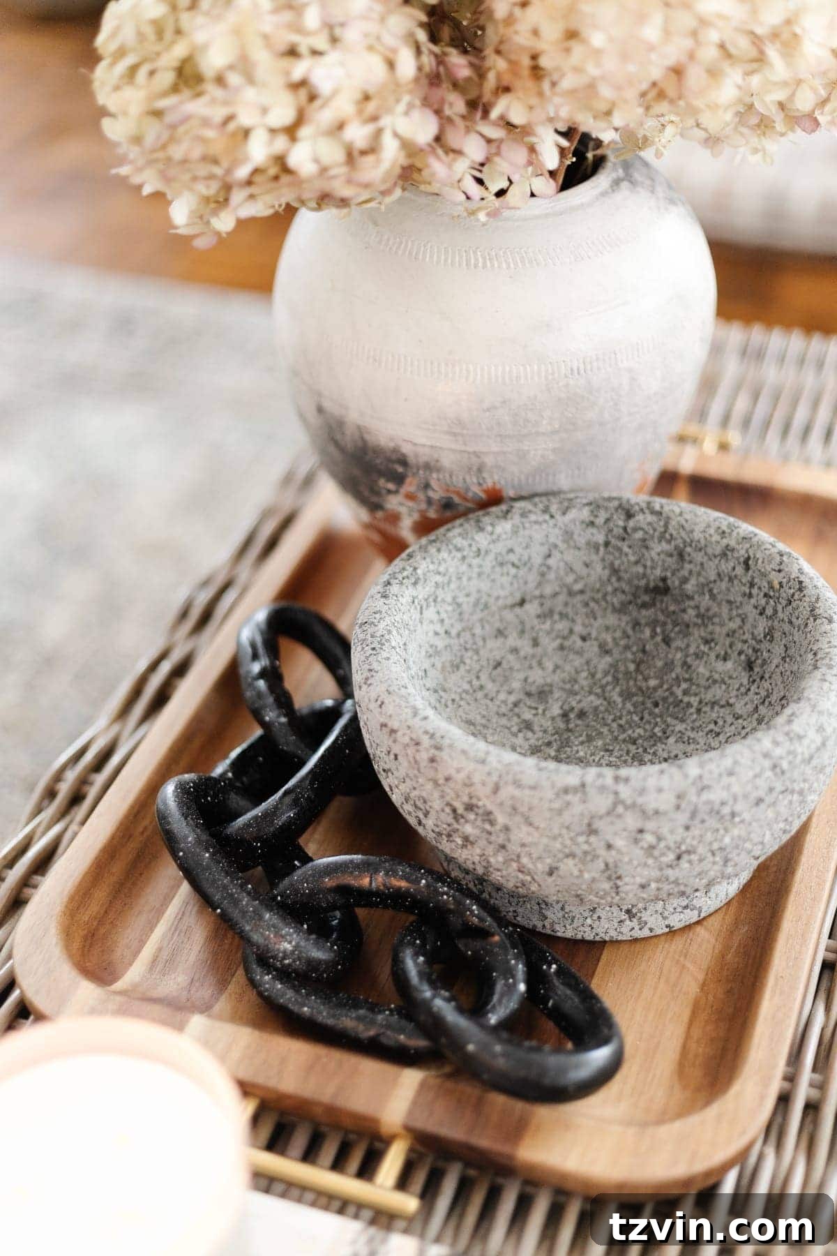 Create Decorative Chains from Air Dry Clay 8 A stylish coffee table vignette featuring the handmade decorative clay chain as a focal point, complemented by books, dried flowers, and a textured tray.