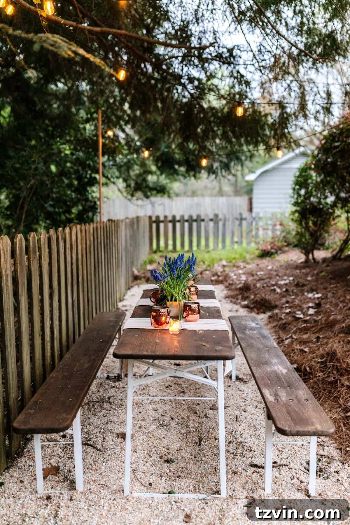 Hanging string lights on wooden dowels to illuminate a DIY backyard dining area, creating a magical ambiance.