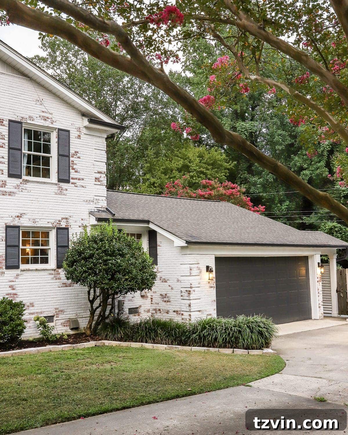 Transformed garage exterior with limewashed brick in Romabio Bianco White and updated outdoor lighting.
