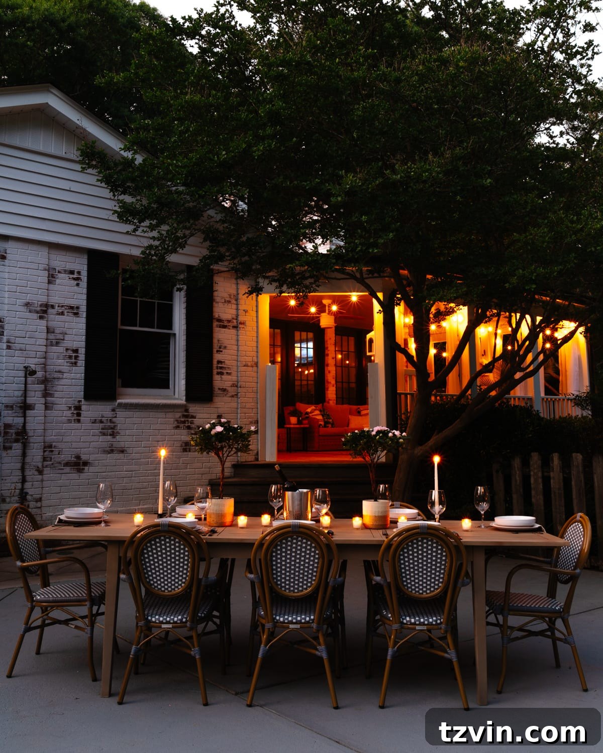 Craft Your Own Driftwood Style Outdoor Dining Table 13 Night time view of backyard patio and back porch with string lights and candlelight